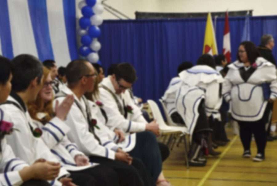 A group of Inuit students dressed in traditional attire at a graduation ceremony, celebrating academic achievements.